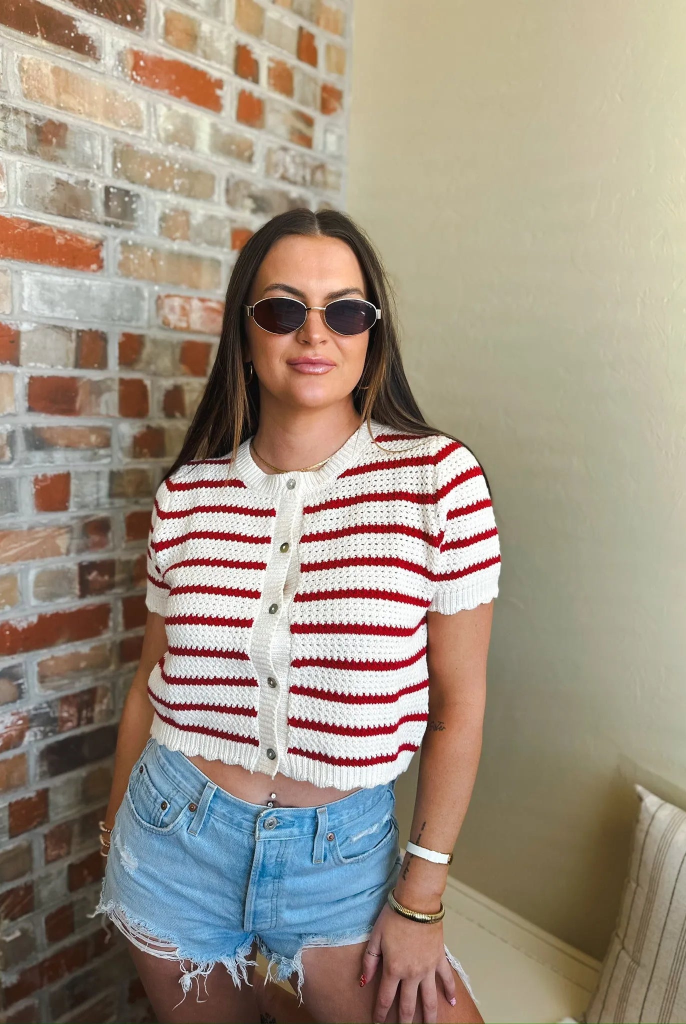 Cropped red and cream striped crochet button-down cardigan sweater with short sleeves.