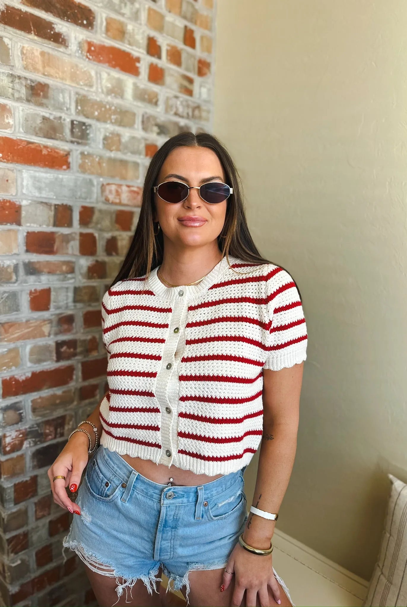 Red and cream striped short sleeve button down cardigan sweater with a white textured knit pattern and wooden buttons.