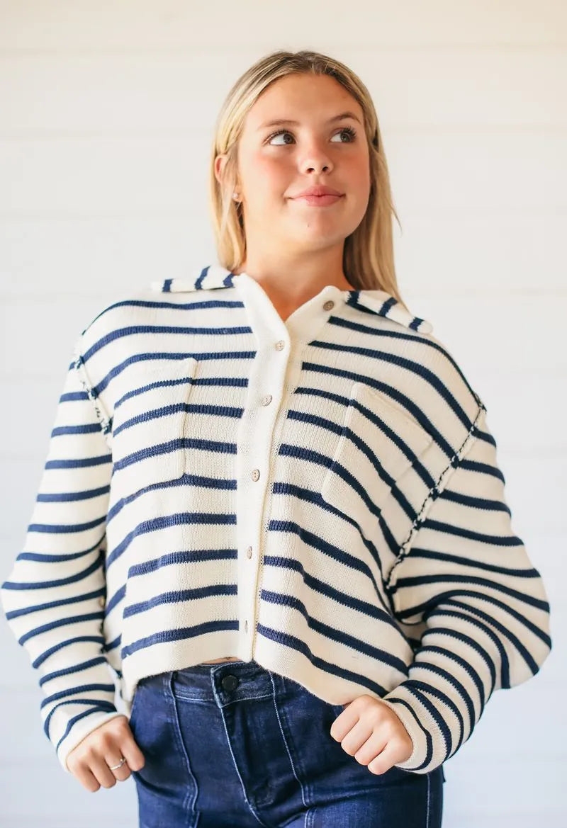 Cream and navy striped relaxed fit button-down sweater with collar and two front pockets.