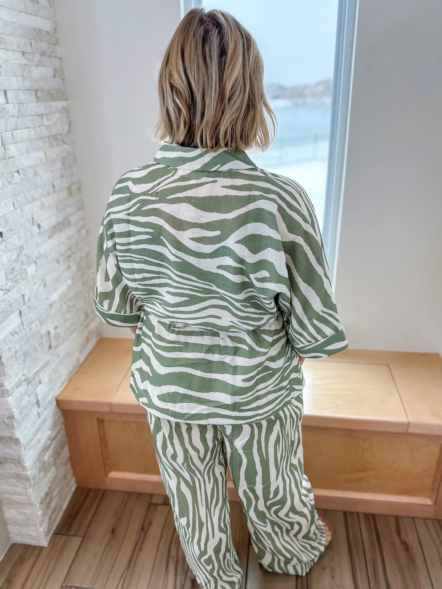 Sage and cream zebra print matching set by ENTRO, back view. Loose-fit button-up top and wide-leg pants.