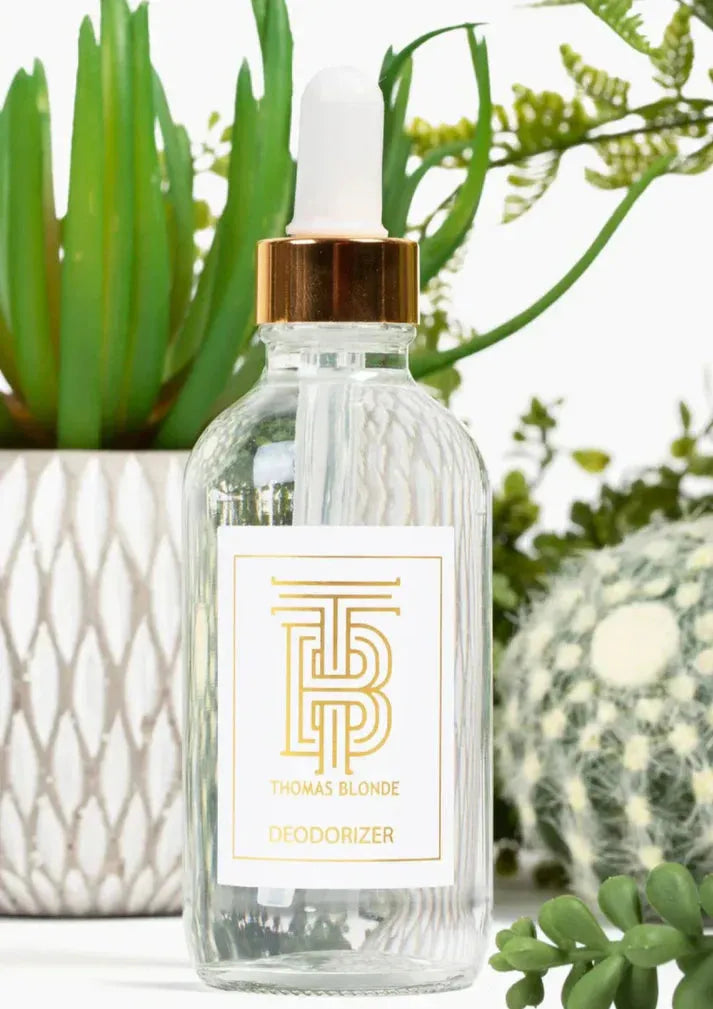 Thomas Blonde Deodorizer glass bottle with dropper, gold cap, and white label featuring a gold TB logo and text.
