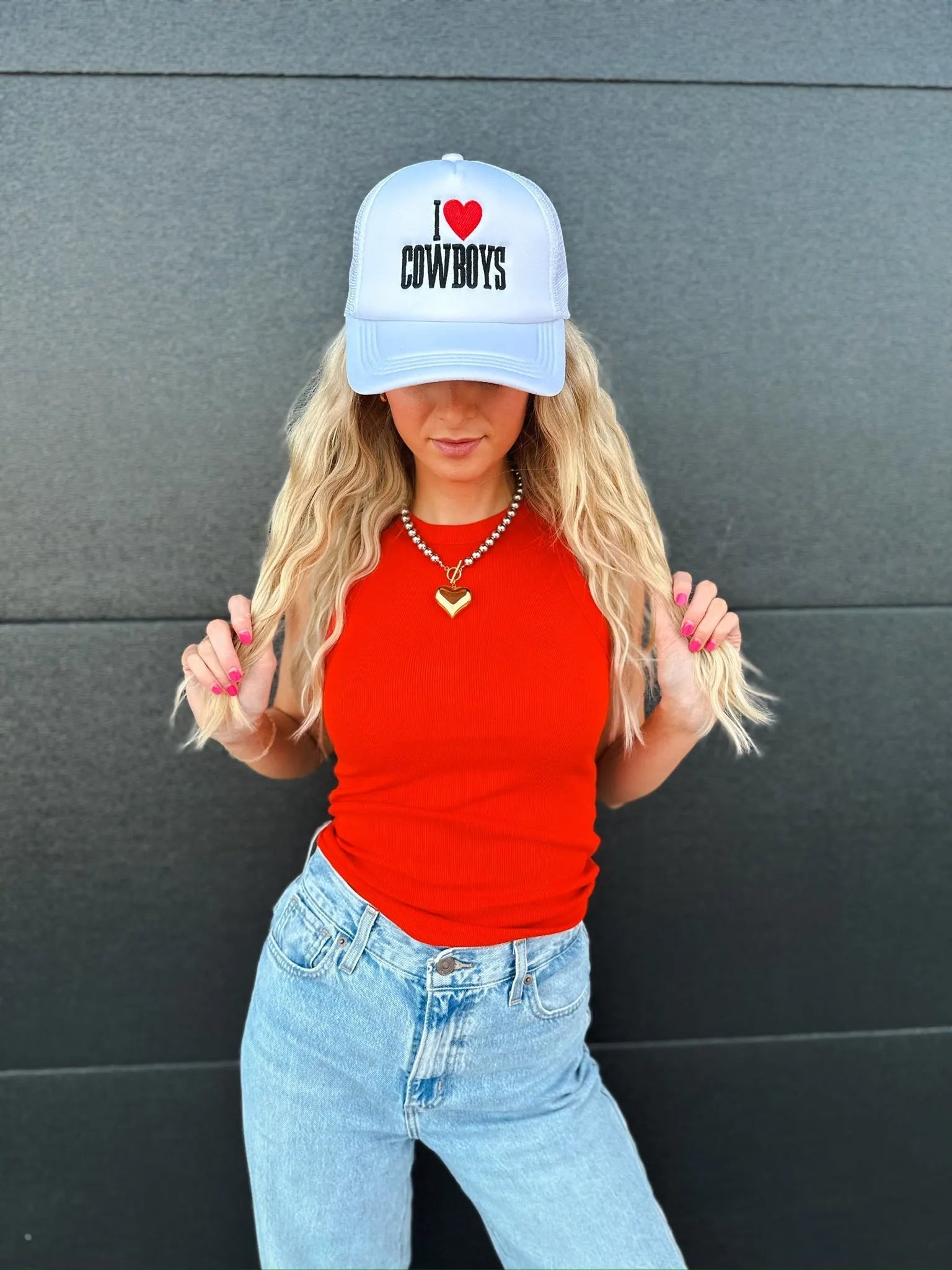 White trucker hat with black text and a red heart graphic that reads "I ♡ COWBOYS".