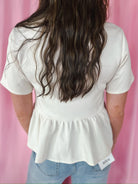 Entro cream jeweled button peplum jacket, short sleeves, gathered waist, and peplum hem. Back view.