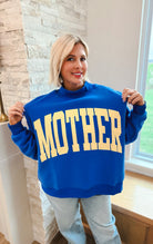 Poppy & Pine royal blue oversized sweatshirt with yellow "MOTHER" text, mockneck, and ribbed cuffs.