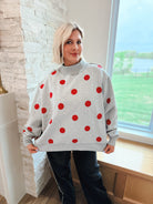 Grey oversized sweatshirt with red polka dots and a mockneck collar.