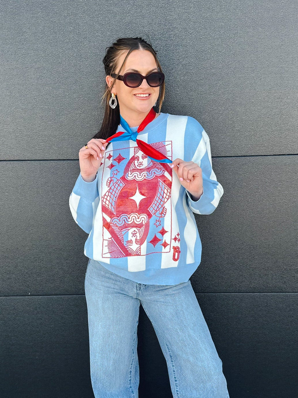 Queen of Sparkles patriotic sweater with blue and white stripes, featuring a red Queen of Hearts card graphic.