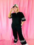 Woman models Black & White Stripe Entro Matching Set: cropped top with striped sleeves, wide-leg pants with white stripes