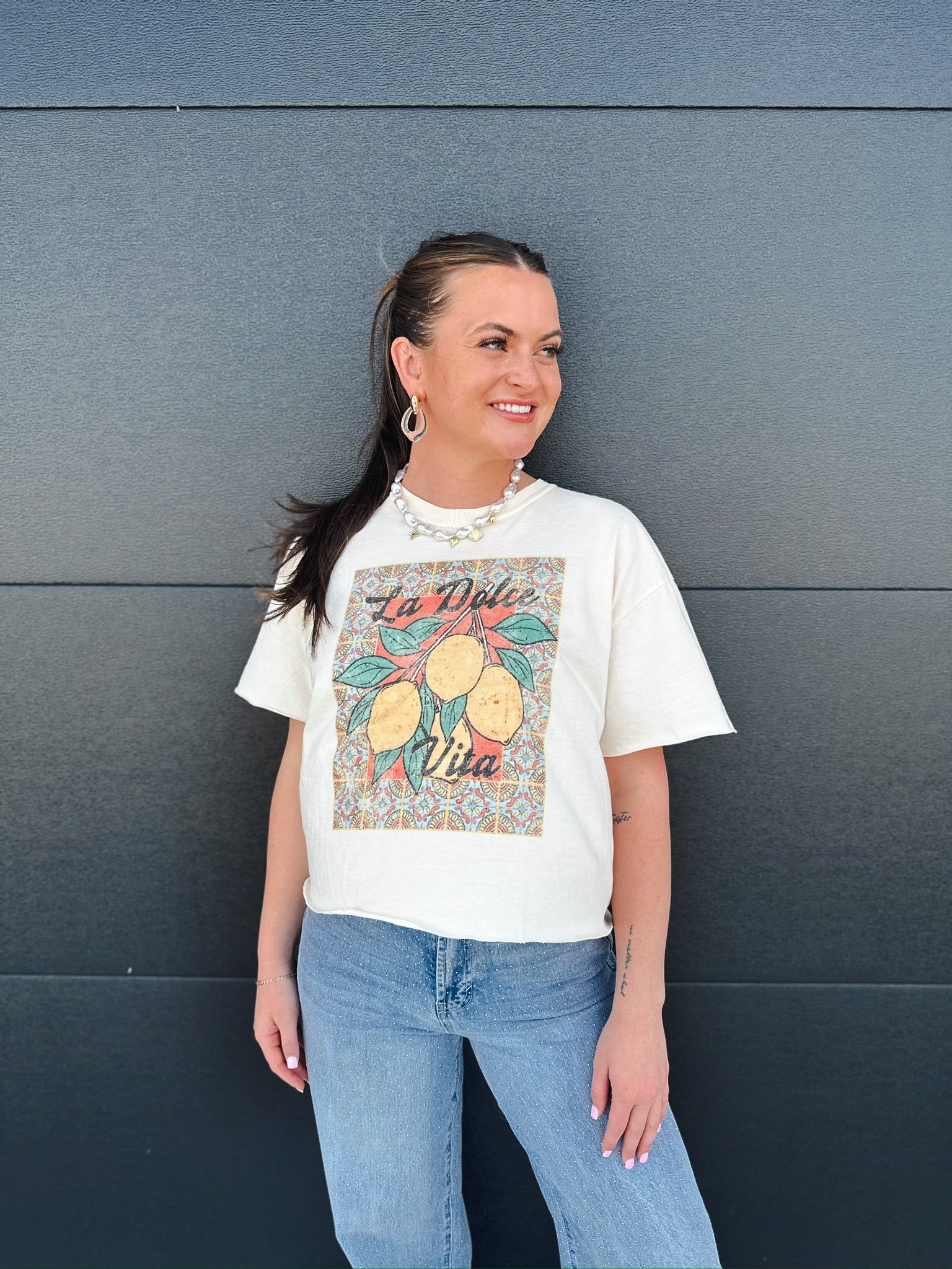 Cream crop tee with vintage lemon graphic and "La Dolce Vita" text, featuring a tiled background pattern.