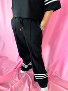 Black & White Stripe Entro Matching Set: Black wide-leg pants with drawstring waist and triple white stripe detail at the