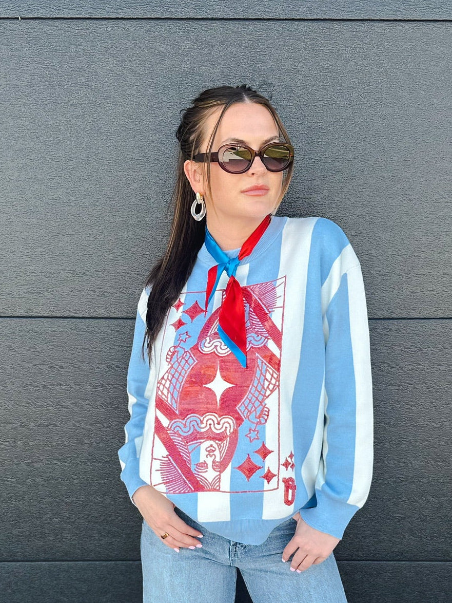 Queen of Sparkles sweater with patriotic stripes, featuring a queen of hearts card graphic with red, white, and blue details.