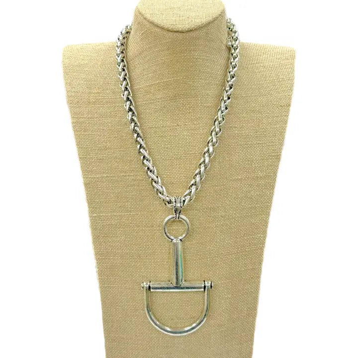 Large silver horse bit necklace with a thick, braided chain, displayed on a mannequin bust.