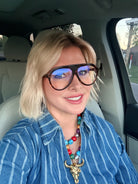 Woman with blonde bob wearing FREYRS MAXWELL bluelight glasses with tortoise frames, a blue striped shirt, and a colorful