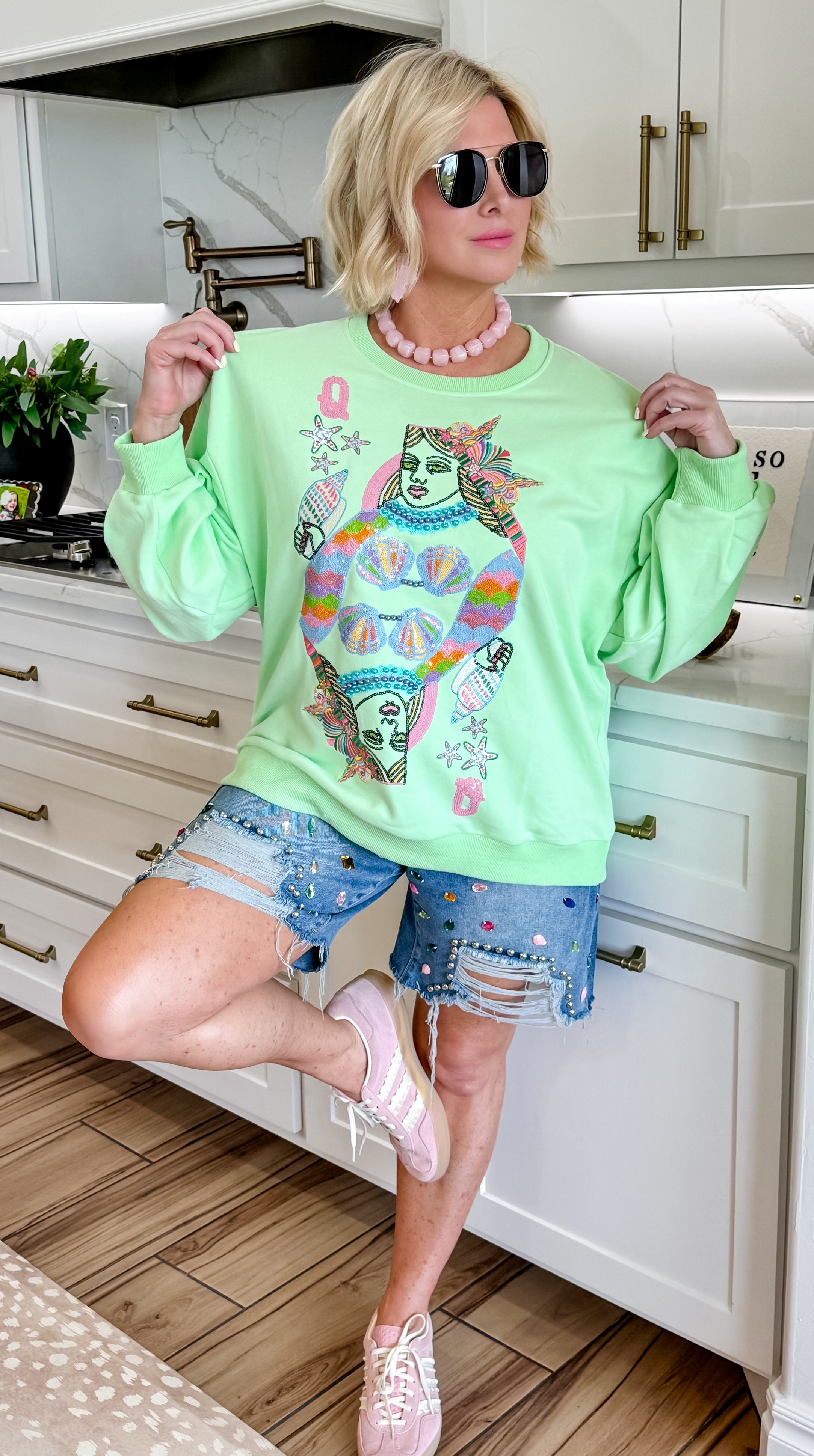 Light green sweatshirt with Queen of the Sea card graphic featuring sequined mermaid and starfish details. Paired with