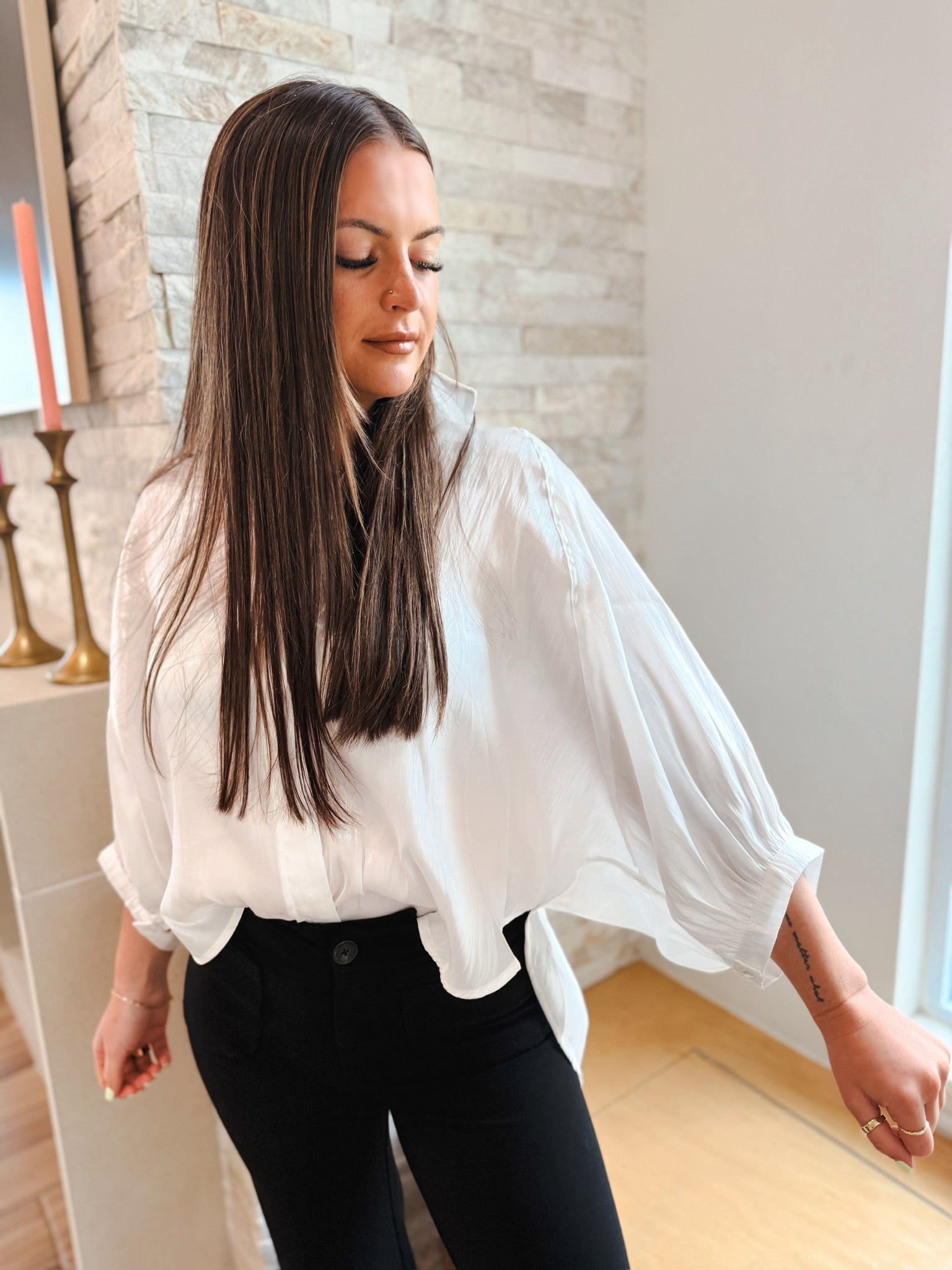 White shiny button front blouse with wide, billowy sleeves. Elevated long sleeve top with a relaxed fit.