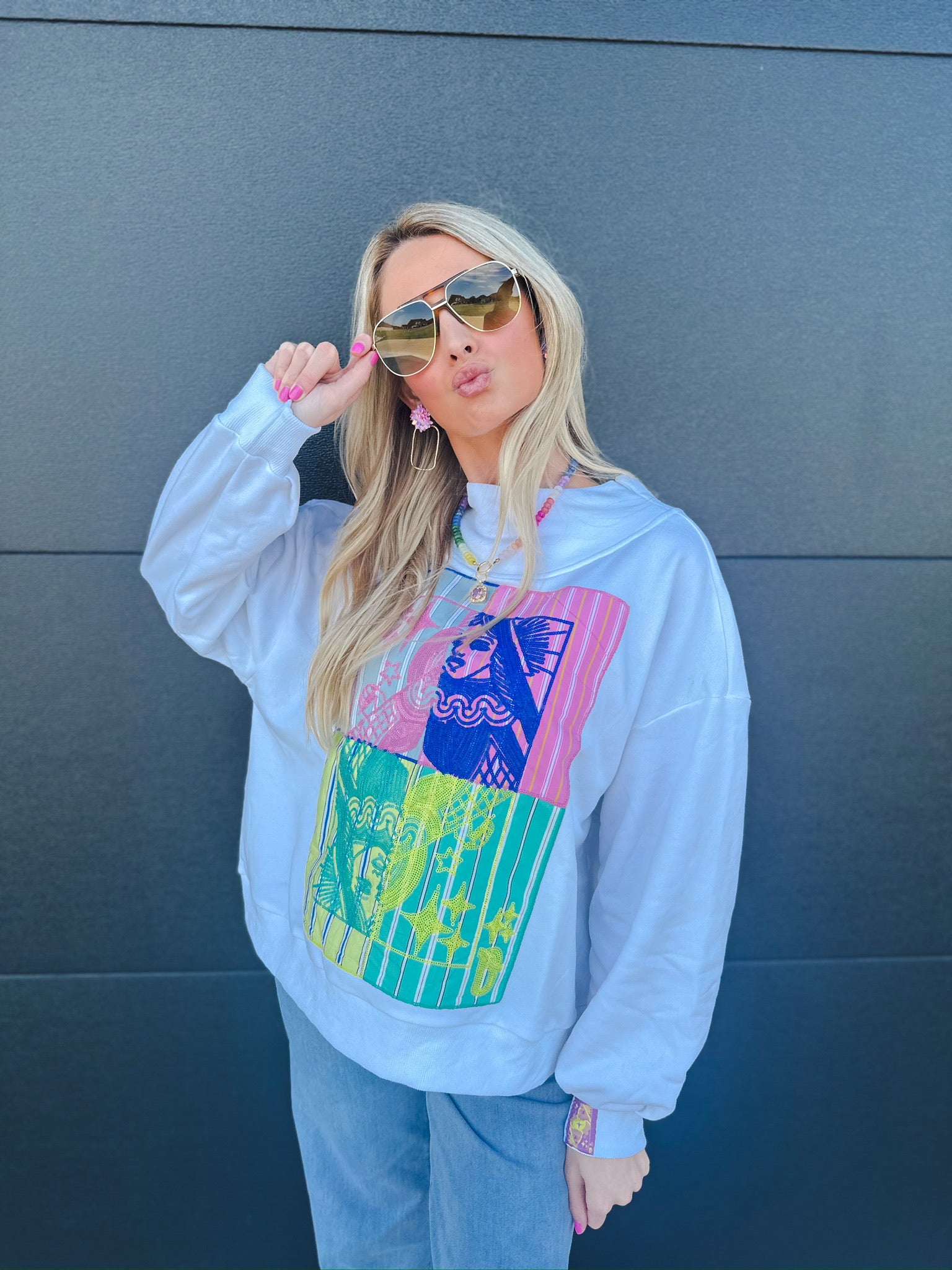 White Queen of Sparkles sweatshirt with colorful graphic art featuring a woman's face and stripes.