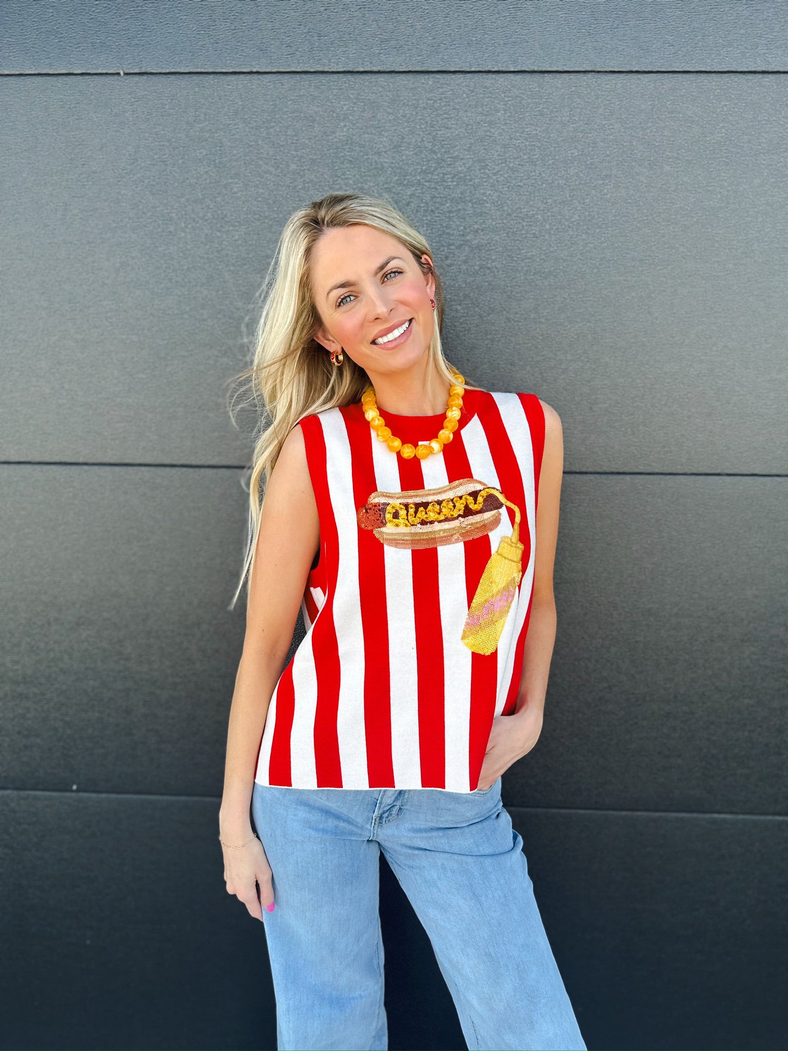 Red and white striped knit tank top with a hot dog and ketchup graphic. Sleeveless design.