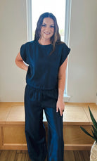 Navy shimmer matching set: short sleeve top with elastic waist and wide leg pants on a smiling woman.