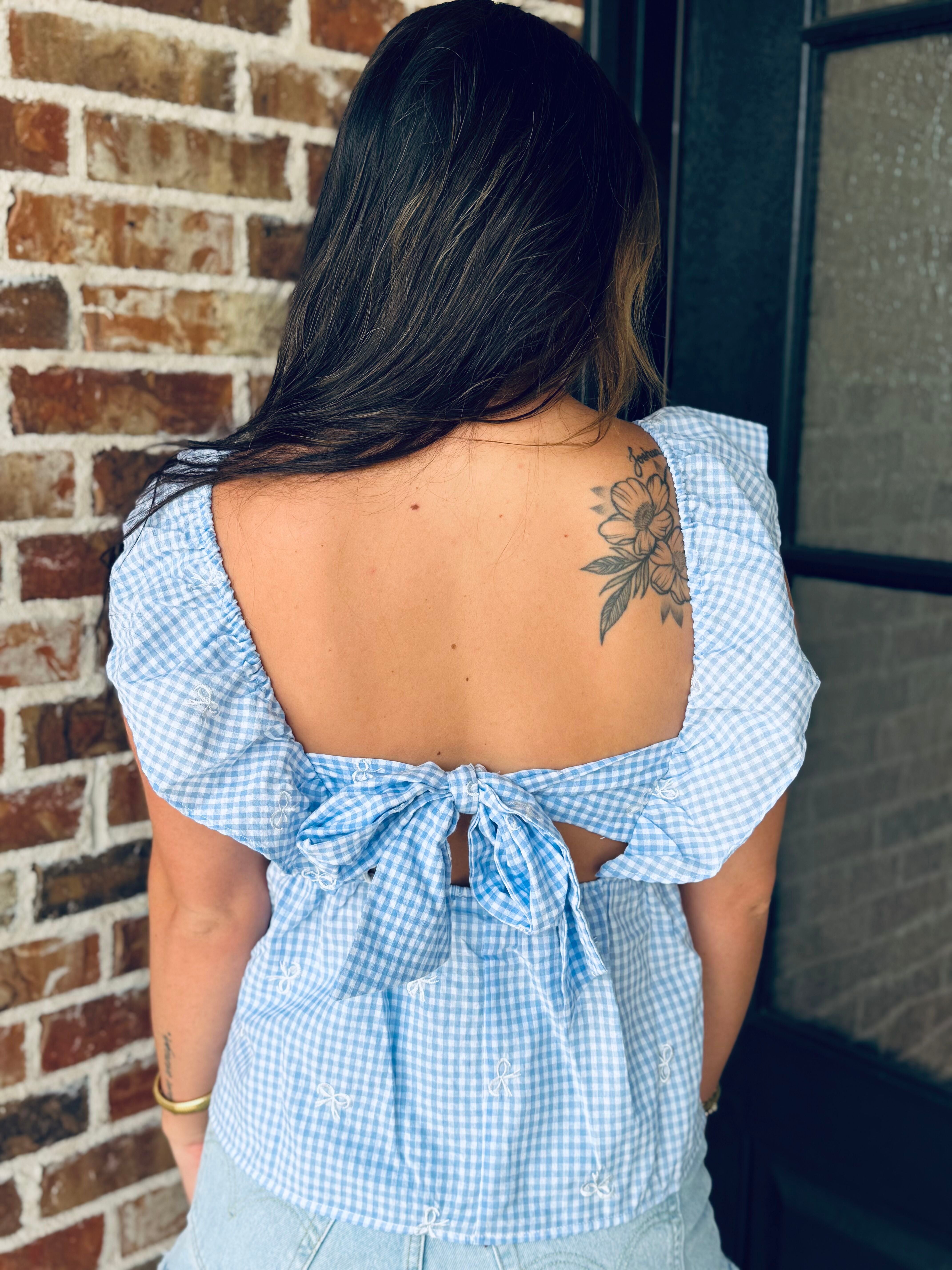 Fashion details of the Blue Gingham Bow Tie Back Top, made from lightweight woven fabric, perfect for a summer-ready wardrobe.