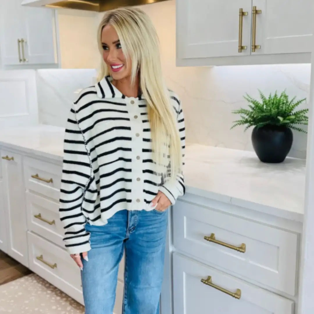 A cozy black-and-white striped knit cardigan with a button-front closure and ribbed cuffs.