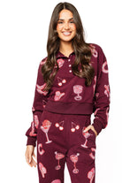 Dark plum pink henley sweatshirt with all-over disco cowgirl icons like cowboy hats, martini glasses, and cherries.