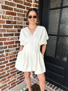 Entro women's cream linen blend V-neck mini dress with short dolman sleeves and functional pockets. Pleated bodice detail.