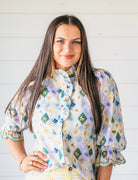 Entro light purple high neck blouse with embroidered floral diamond pattern and ruffle sleeves.