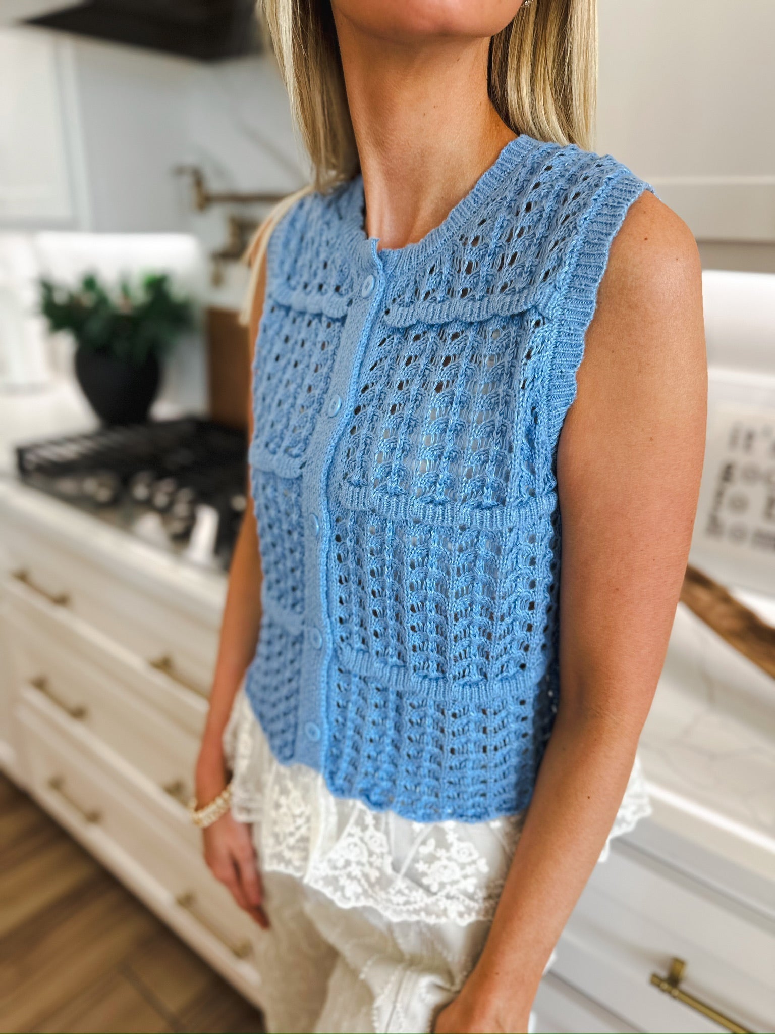Entro periwinkle blue sleeveless knit cardigan with white lace trim and pearl buttons. Open knit pattern.