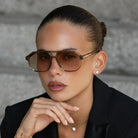 Freyrs Billie Unisex Aviator Sunglasses: Model with brown gradient lenses & thick translucent brown frames, resting chin on
