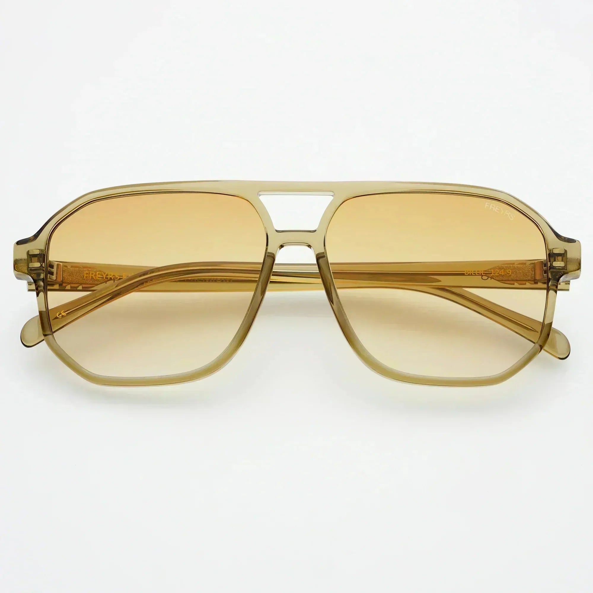 Freyrs Billie unisex aviator sunglasses with amber gradient lenses and translucent beige frames, on a white background.