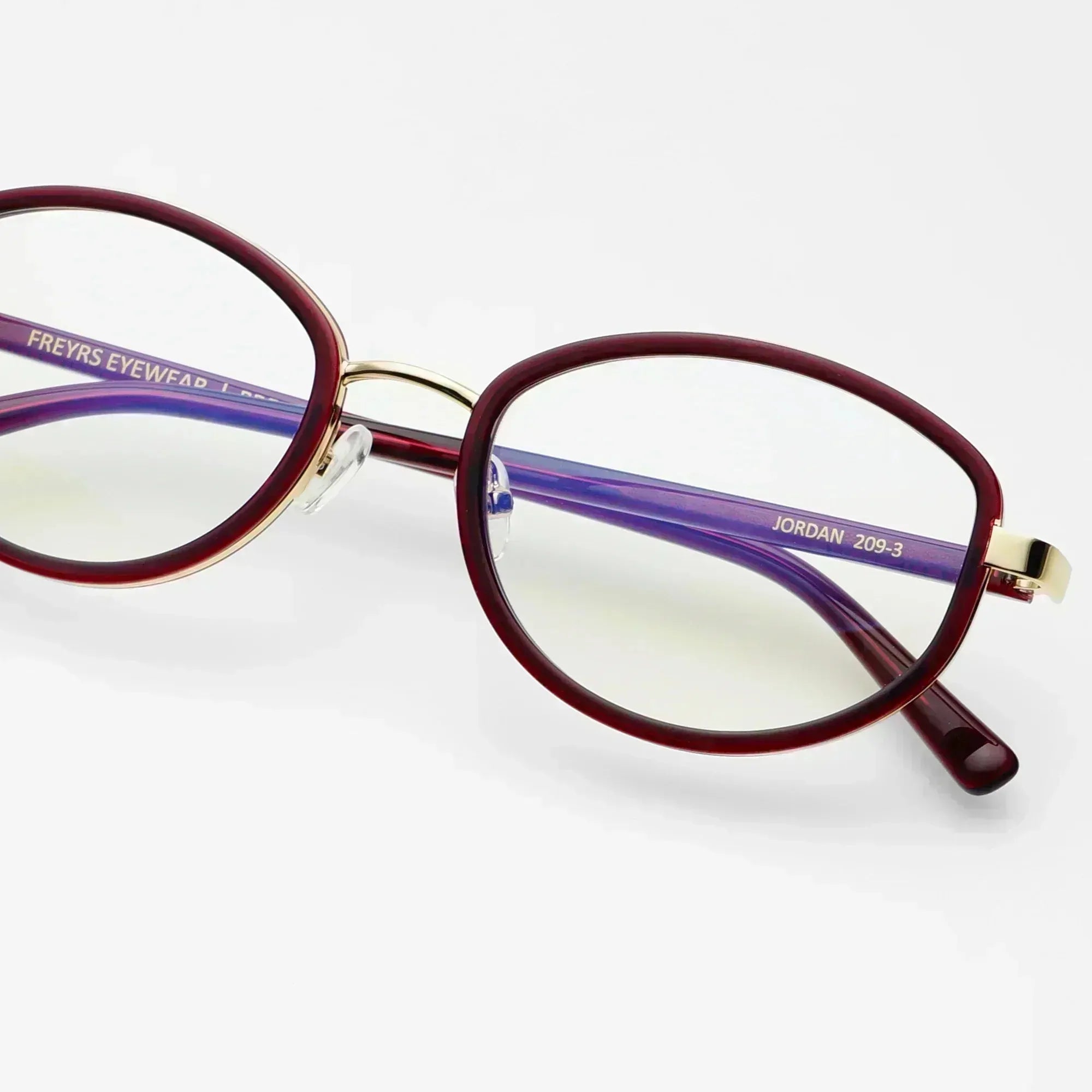 Freyrs Jordan modern oval blue light glasses with burgundy rims, gold accents, and purple temples. Model number JORDAN 209-3.