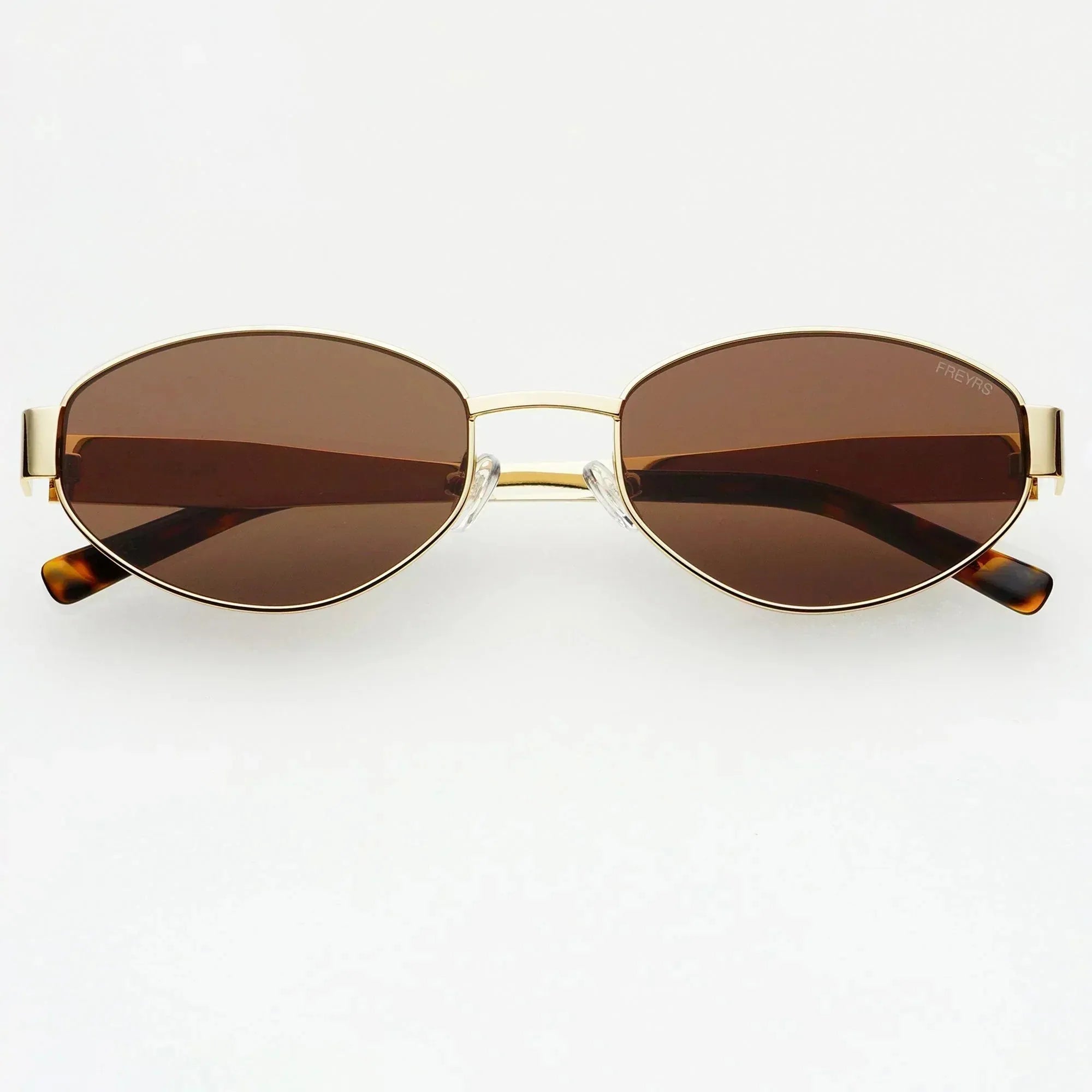 Freyrs Soho small oval sunglasses with gold frame and brown lenses. Tortoiseshell temple tips.