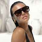 Freyrs Voyager oversized aviator sunglasses with tortoiseshell frames and gradient lenses on a wet woman in a black swimsuit.