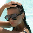 Freyrs Voyager oversized aviator sunglasses with tortoiseshell frames and dark gradient lenses. Model wears them in a pool