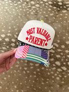 White snapback hat with pink polka dots and red embroidered text "MOST VALUABLE PARENT" with patchwork brim.