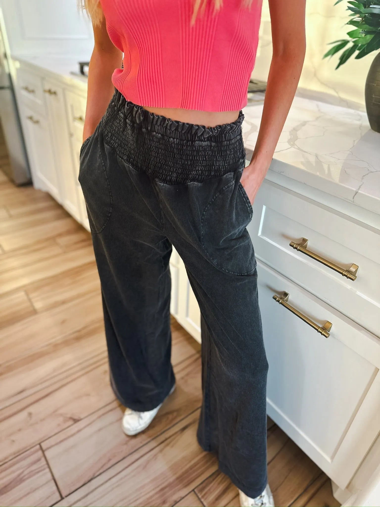 Woman wearing HyFVE black wash elastic waist wide leg trousers with pockets and a pink crop top.