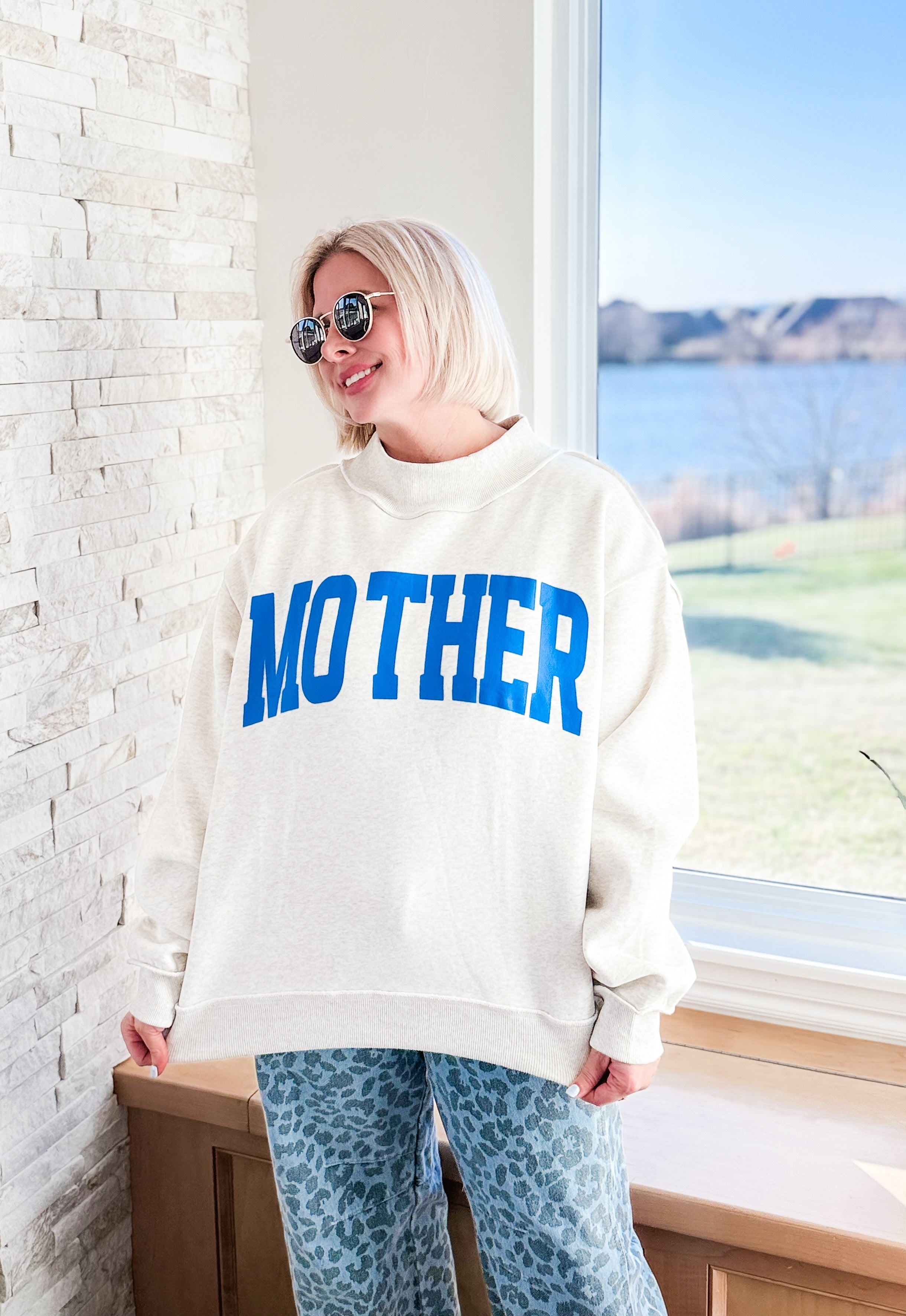 Woman wearing a heather grey mock neck sweatshirt with