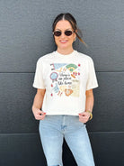 Cream graphic tee with "No Place Like Home" baseball design. Features baseballs, gloves, bats, and a fan finger.