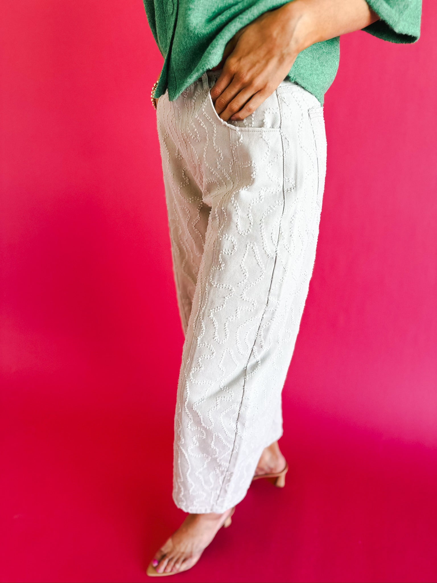 Ecru twill denim barrel pants with a white textured pattern and frayed hem, worn by a model with a green top.
