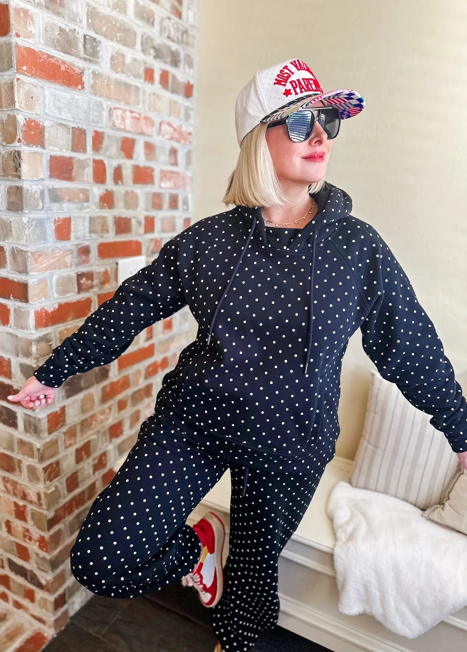 Poppy and Pine black and white polka dot loungewear set. Woman wearing a black hoodie and matching pants with white polka