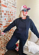 Poppy and Pine black and white polka dot loungewear set. Woman wearing a black hoodie and matching pants with white polka