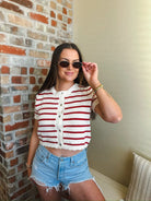 Woman wearing a red and cream striped short sleeve button-down cardigan sweater with crochet detail, paired with denim