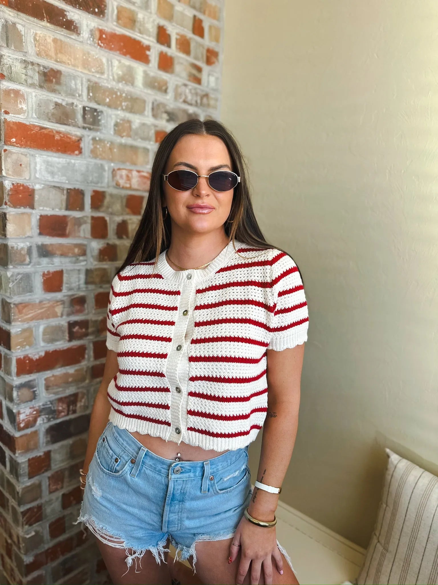 Cropped red and cream striped crochet button-down cardigan sweater with short sleeves.