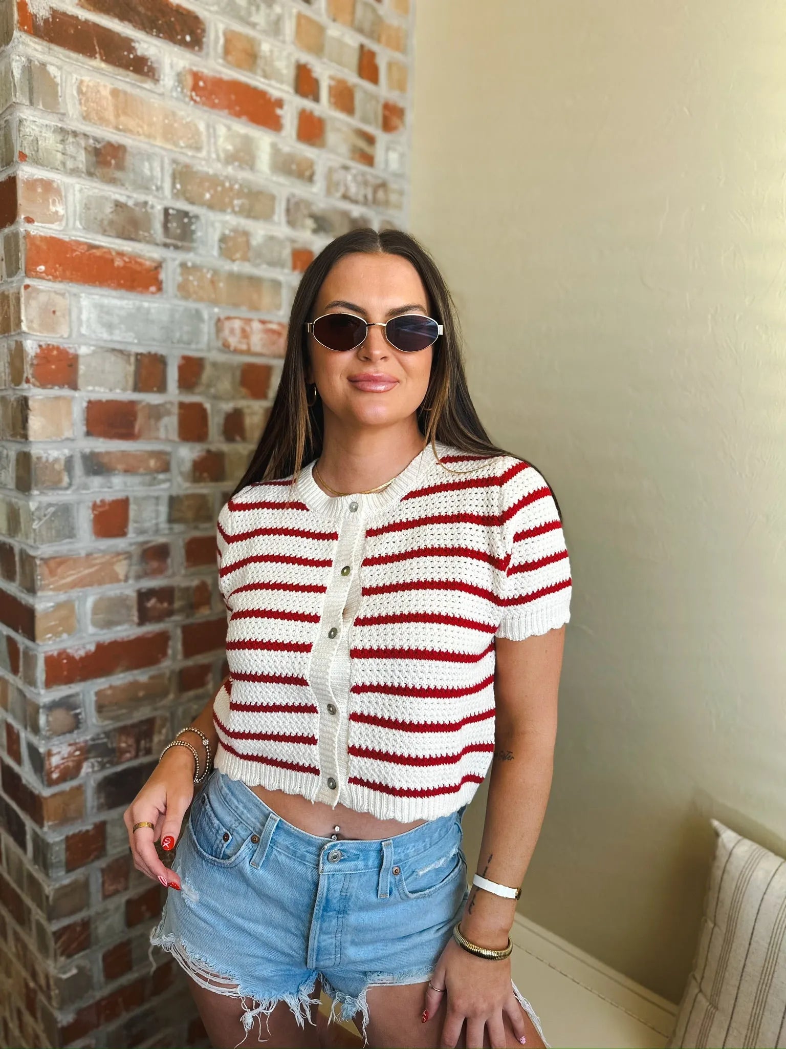 Red and cream striped short sleeve button down cardigan sweater with a white textured knit pattern and wooden buttons.