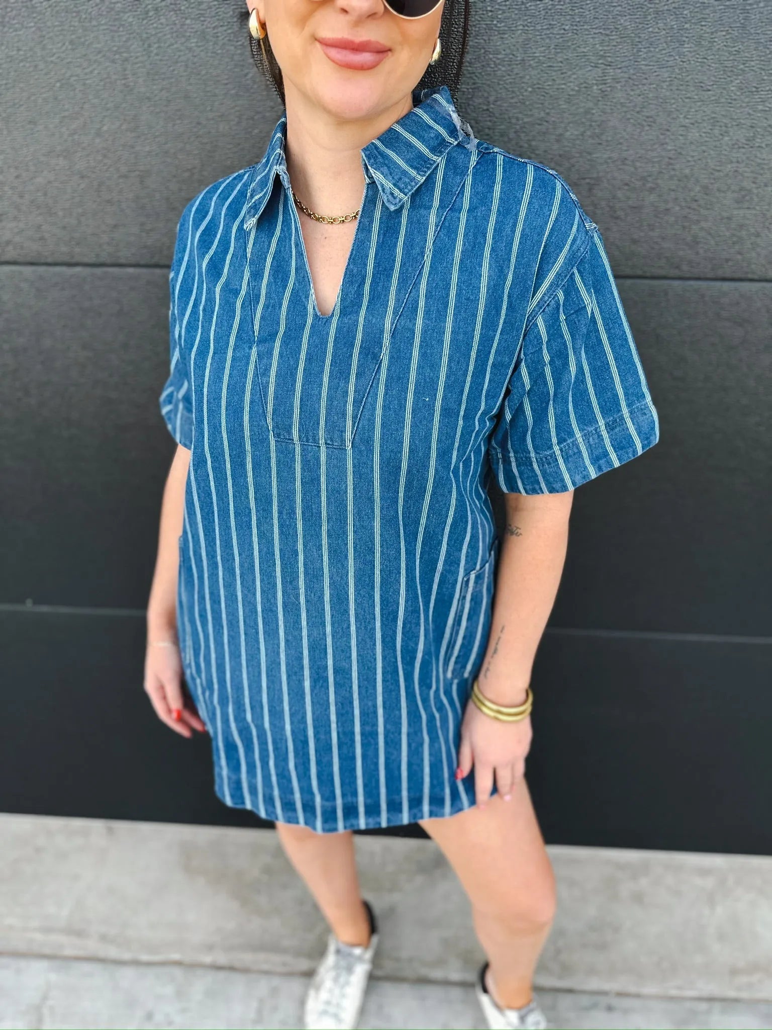 Relaxed fit blue denim dress with white vertical stripes, short sleeves, and a split neckline.