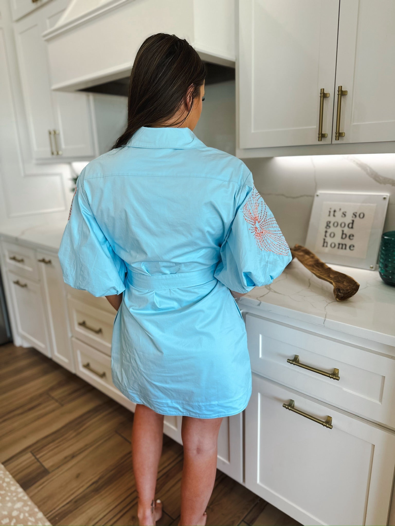 Light blue mini dress with puff sleeves featuring intricate floral embroidery on the shoulders and a tie waist.