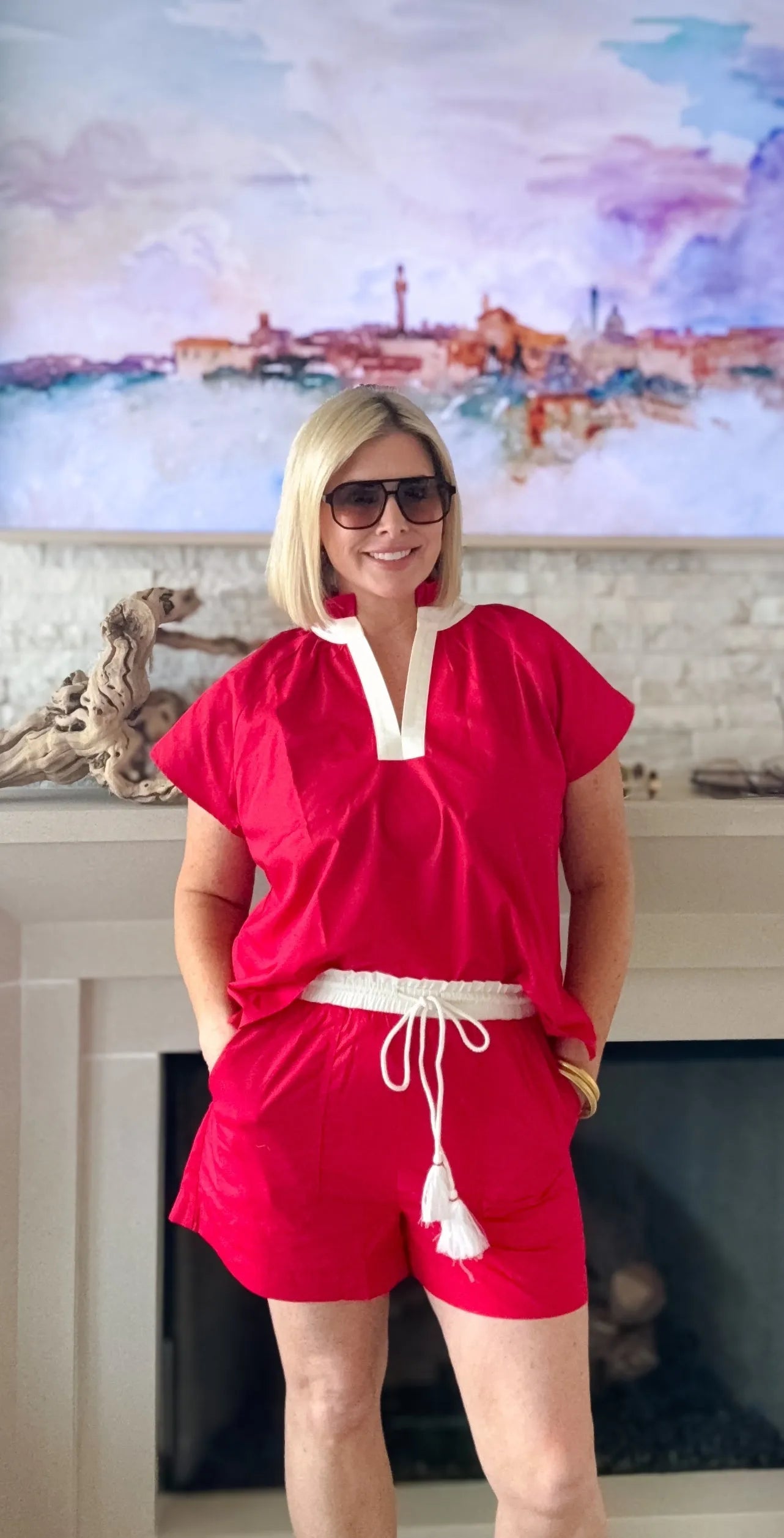 Entro red short set with cream trim and white drawstring with tassels, worn by a woman with blonde hair and sunglasses.