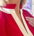 Entro red short set with cream trim and ruffled collar. Close-up showing neckline detail on a woman.